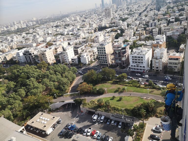 מטפס חבלים מעל פנורמת העיר